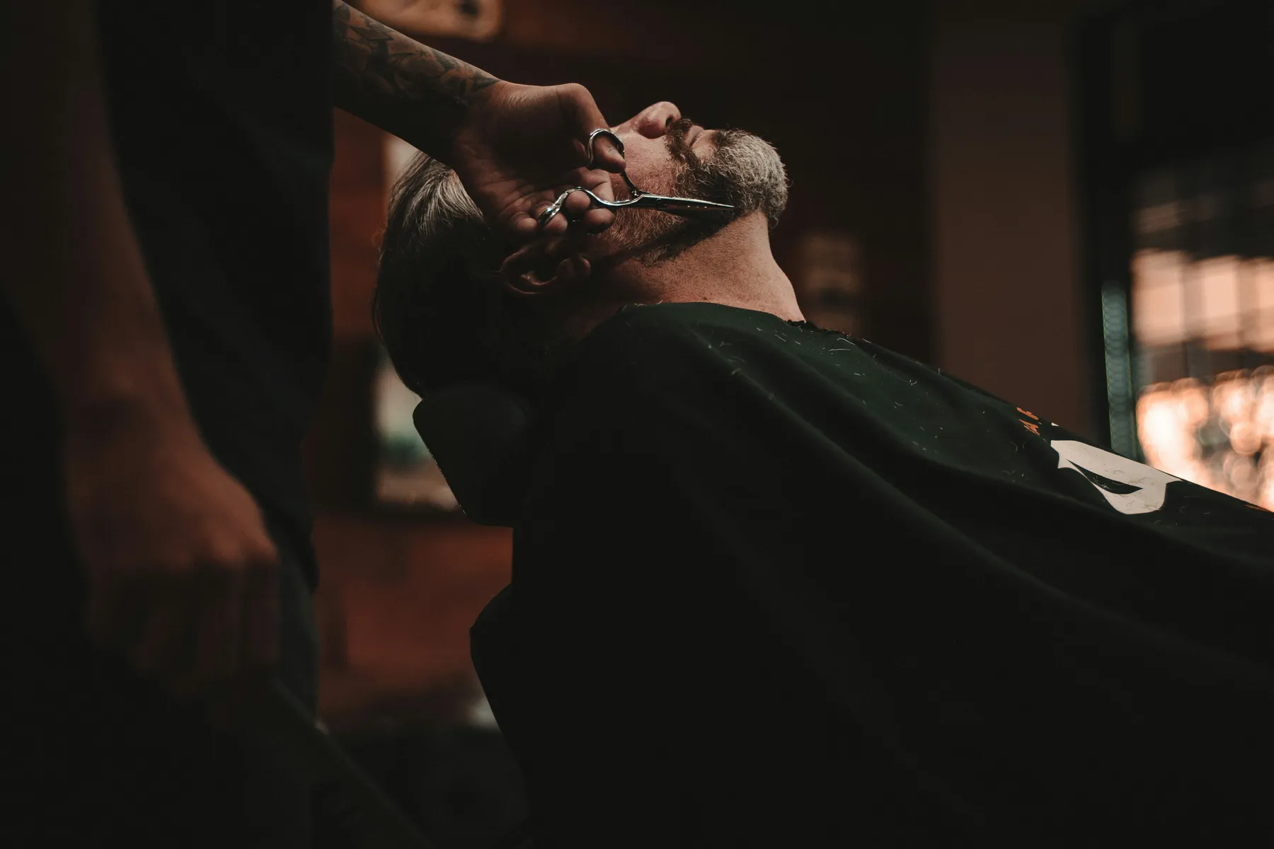 Rasage aux ciseaux dans la pénombre du salon